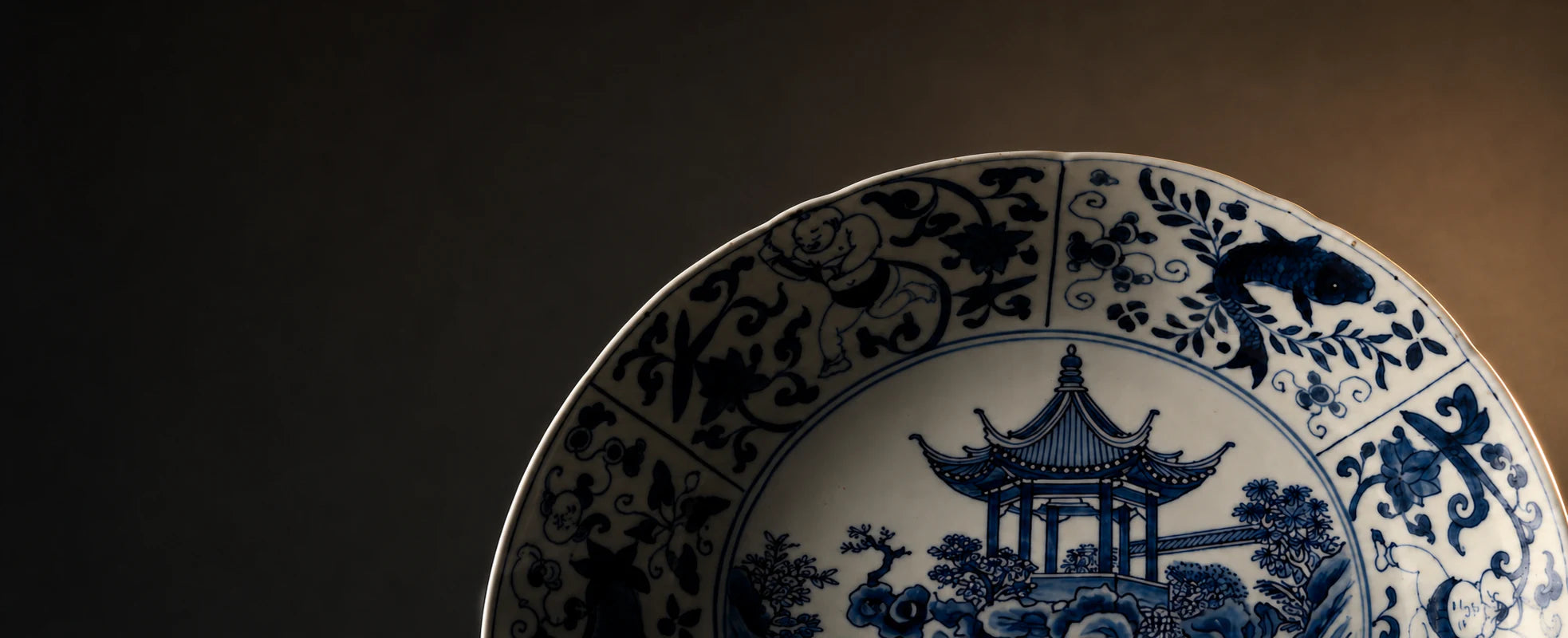 Blue-and-white porcelain plate featuring a classical Chinese garden pavilion